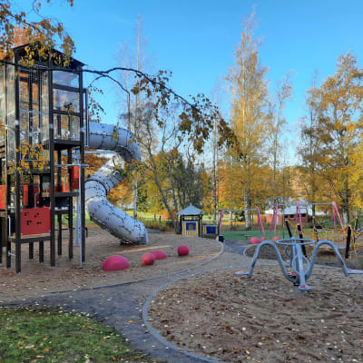 Myllyrannan tapahtumapuiston leikkipaikalla on muun muassa punamusta kiipeilytorni, harmaa putkiliukumäki ja vaaleanpunaisia keinuja.