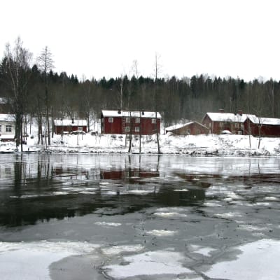 En isig å och hus vid kanten av ån.