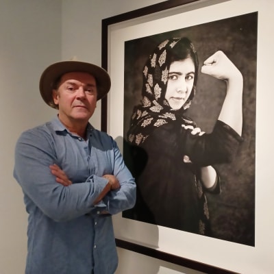 Den rikssvenska fotografen Albert Wiking framför hans porträtt av den kvinnliga pakistanska människorättsaktivisten Malala Yousafzai.