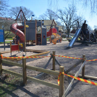 En lekpark som är avgränsad med band.