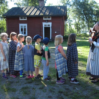 Barn på traditionsläger på Brage Friluftsmuseum tillsammans med guide Jenny Holm