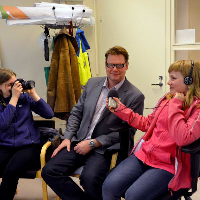 Kaia Paukku och Alicia Äbb från Ekenäs högstadieskola intervjuar och fotar tekniska direktören i Raseborg, Jan Gröndahl.