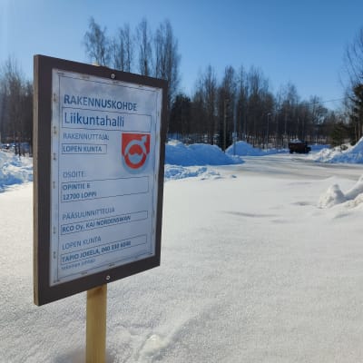 Uuden liikuntahallin maa-alueella oleva kyltti rakentamisesta.