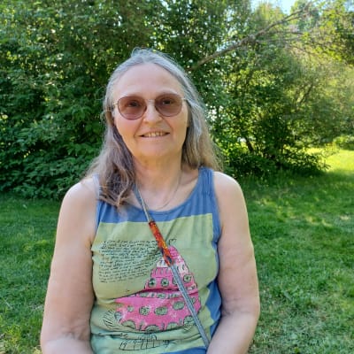 Eva Hietanen, som grundade Myrbergsteatern, sitter i en trädgård