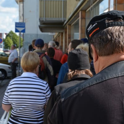Människor väntar på mat i en lång brödkö i Åbo.