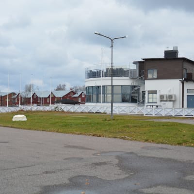 Restaurangen hsf i Hangö syns bakifrån och i bakgrunden de röda magasinen längs Hamngatan.