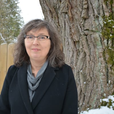 En kvinna i svart jacka står ute vid en ek. Hon heter Tina Nordman.