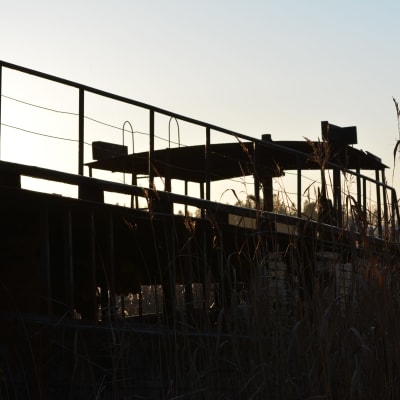 profilbild av skrotbåten i solnedgång.