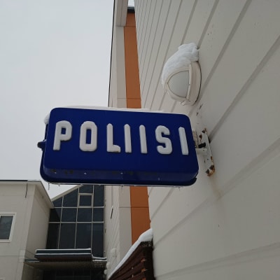 Poliisi-kyltti poliisilaitoksen seinässä.