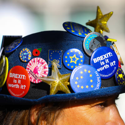 Mielenosoittajan hattu on täynnä brexitiä vastustavia rintamerkkejä.