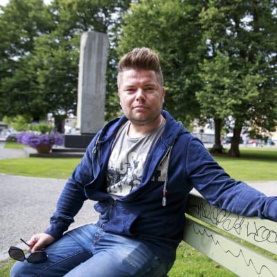 Jussi Parkkila sitter på en parkbänk