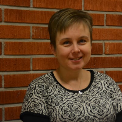 kvinna invid tegelvägg