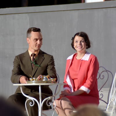 Leif Wadenström i rollen som kapten von Trapp sitter vid ett bord tillsammans med baronessan Elsa Schraeder (Jennifer Karlsson).
