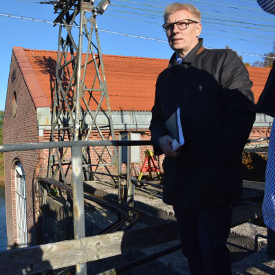 Jordbruks- och miljöminister Kimmo Tiilikainen bekantar sig  med fiskvägarna i Billnäs som ska byggas strax nedanför platsen där han står.