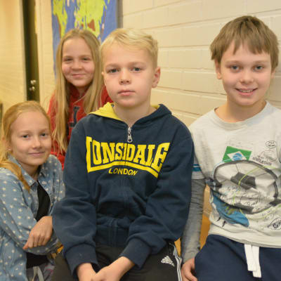 Elever i Sjundeå svenska skola sitter på bord och stolar. Här syns Leia Seppä (längst bak), Wilma Holmberg, Walter Forsén och Robert Siro.