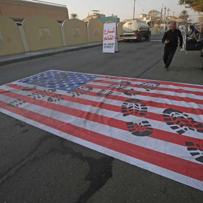 USA:s flagga ligger på vägen i Bagdad i Irak efter USA:s flygattack mot högt uppsatta ledare i Mellanöstern.