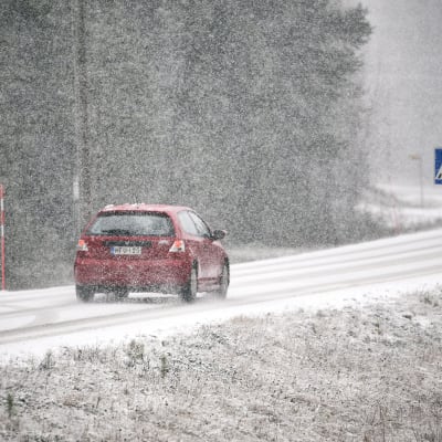 auto tiellä ja lunta sataa