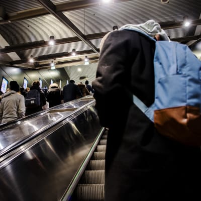 Människor står i en rulltrappa