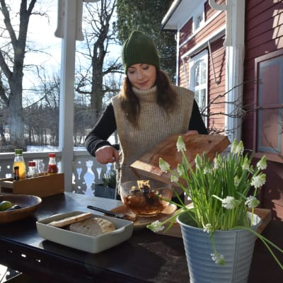 En kvinna gör mat utomhus