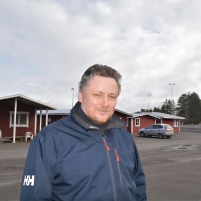 Man vid sjöbodar