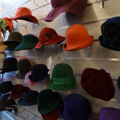 Färggranna damhattar på en ställning i hattaffären.