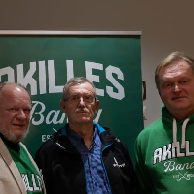 Tre män med Akilles bandyskjortor.