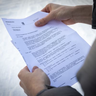 Ett påminnelsebrev gällande hälsovårdsavgiften hör högskolestuderande. En studerande håller pappret i händerna.