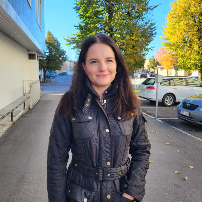 En kvinna som står på en bakgård. 