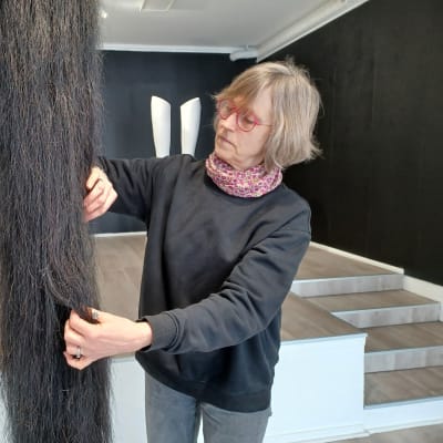 Vasakonstnären Mia Damberg rättar till sin skulptur Hommage to a great horse som ser ut som en överdimensionerad hästsvans