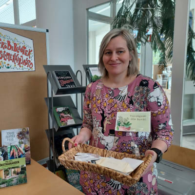 Korsholms bibliotekschef Maria Kronqvist-Berg visar upp en korg med fröpåsar ur fröbiblioteket