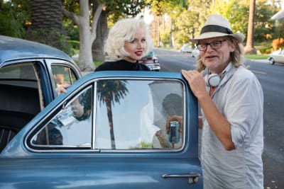 Ana de Armas och regissören Andrew Dominik står vid en gammal bil och pratar under inspelningen av filmen Blonde.