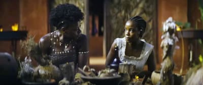 Nanisca (Viola Davis) och Nawi (Thuseo Mbedu) sitter bredvid varandra vid ett altare och ser allvarliga på varandra.