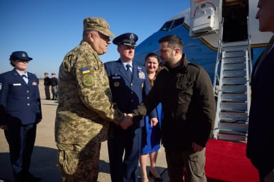 Zelenskyj skakar hand med en militär utanför sitt flygplan.