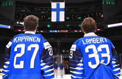Oliver Kapanen och Brad Lambert tittar på Finlands flagga.