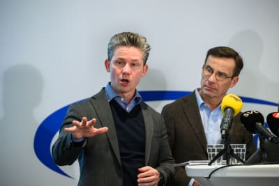 Pål Jonson står vid ett podium tillsammans med Ulf Kristersson