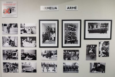 Svartvita fotografier med armétema hänger på en vägg