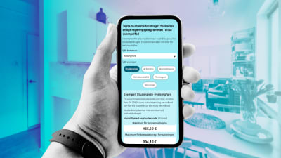 Bilden visar en svartvit hand som håller i en smarttelefon. På telefonskärmen finns Yles bostadsbidragskalkylator som visar effekterna av det nya regeringsprogrammet i olika bostadsbidragsscenarier. I bakgrunden syns lägenhetens kök i olika blå nyanser.