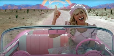 På bilden en blond kvinna iklädd en rosa basker och håret i en fläta. Hon kör en rosa bil utan tak. 