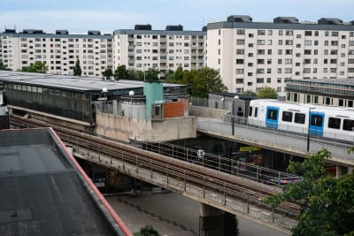 Bild på höghus och en tunnelbana som kommer åkandes.