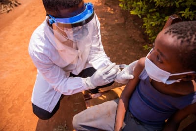 En läkare vaccinerar ett barn i Afrika under ett läkarbesök.