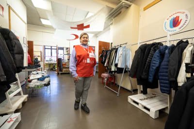 Röda Korsets frivilligarbetare i korridor omgiven av kläder