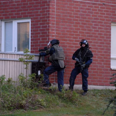 Polis i tung utrustning utanför en lägenhet i Mäkkylä, Esbo.