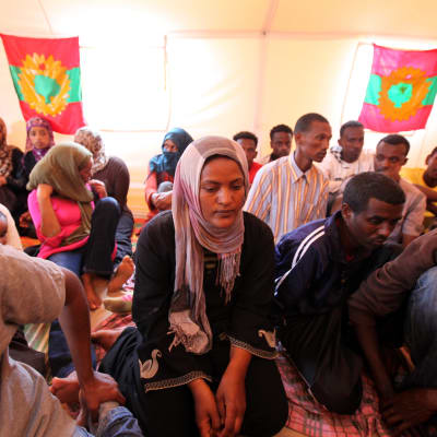 Flyktingar från Oromo i Libyen sörjer drunknade flyktingar. I bakgrunden syns rebellflaggan för Oromos Befrielsefront