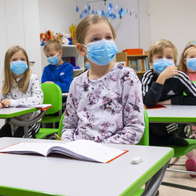 Vaunukankaan koulun ensimmäisen luokan oppilaita tunnilla kasvomaskit kasvoillaan. 