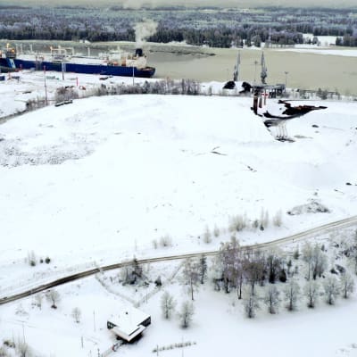 Djuphamnen i Ingå med LNG-fartyget vid kajen på en bild tagen från luften. Snö täcker marken framför hamen och på andra sidan vattnet sträcker sig skog.