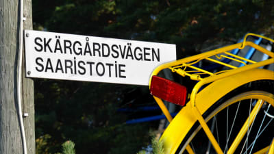 Skylt med texten Skärgårdsvägen och en gul cykel.