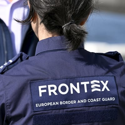 Två personer från Europeiska gräns- och kustbevakningsbyrån i blå uniform. Man ser bara en del av övrekroppen, inga ansikten.