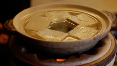 Tofubitar i en skål med hett vatten.