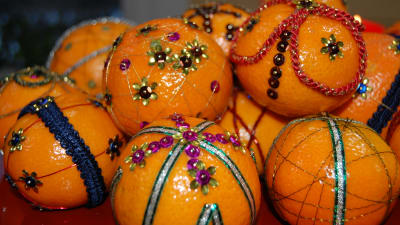 Mandariner som dekorerats med paljetter och sidenband i olika färger och mönster.