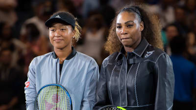 Naomi Osaka och Serena Williams står på varsin sida om tennisnätet bredvid varandra.